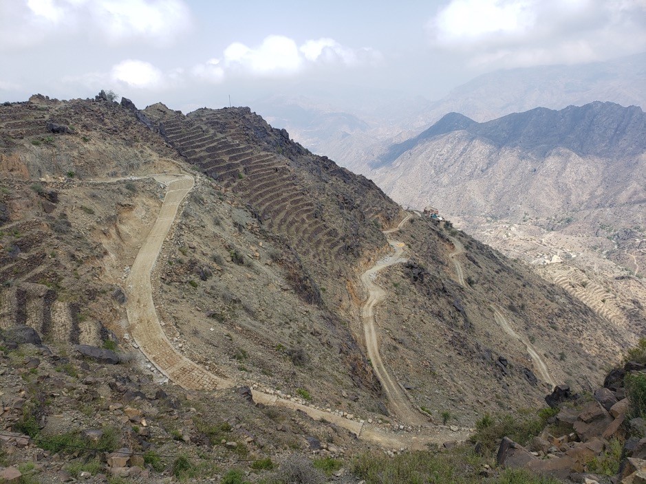 A winding mountain road cutting through rocky terrain.