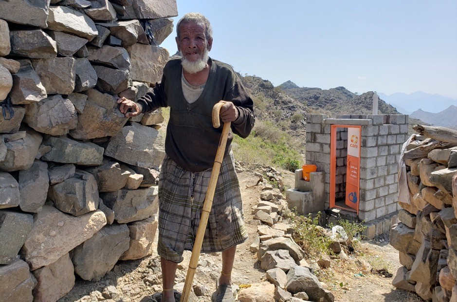 A man standing next to a pile of rocks