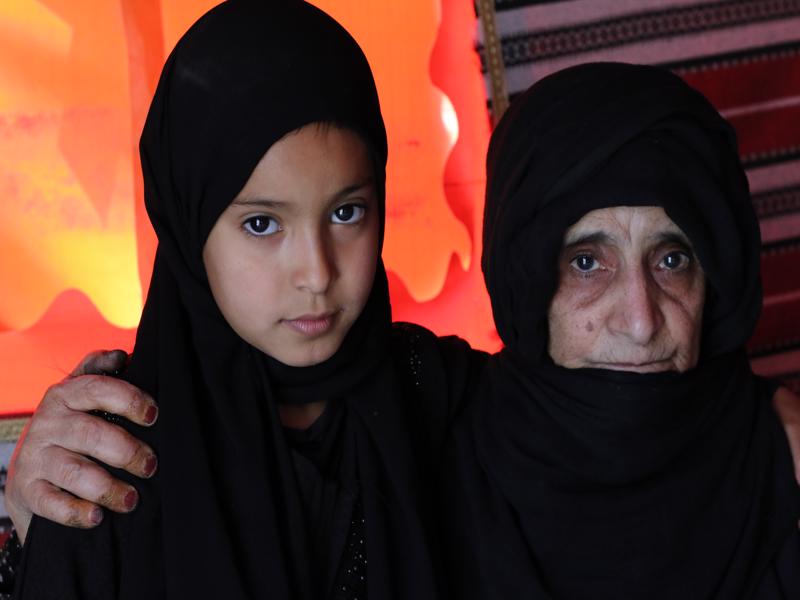 a woman and a child wearing black headscarves