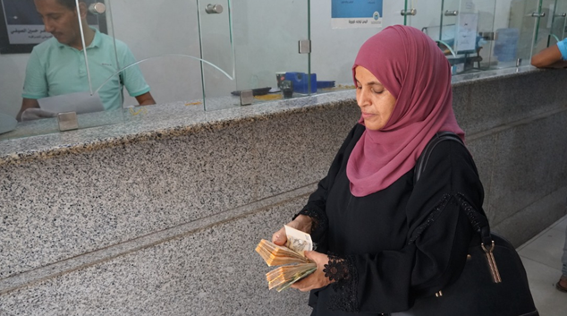 A woman holding a bundle of money