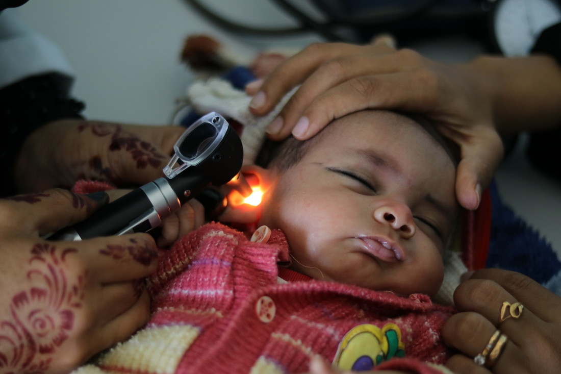 A baby being examined by a doctor
