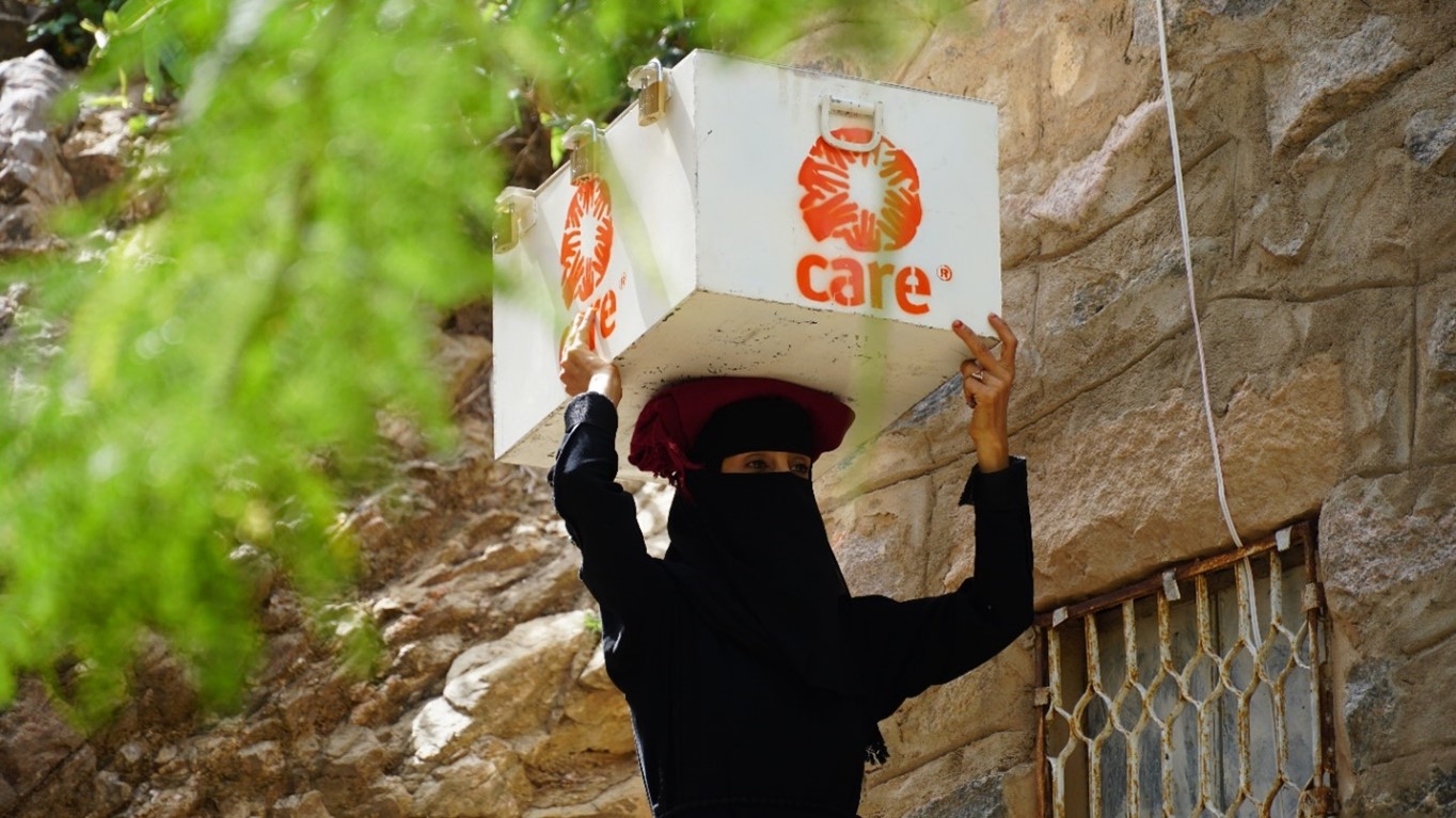 A woman carrying a white box on her head