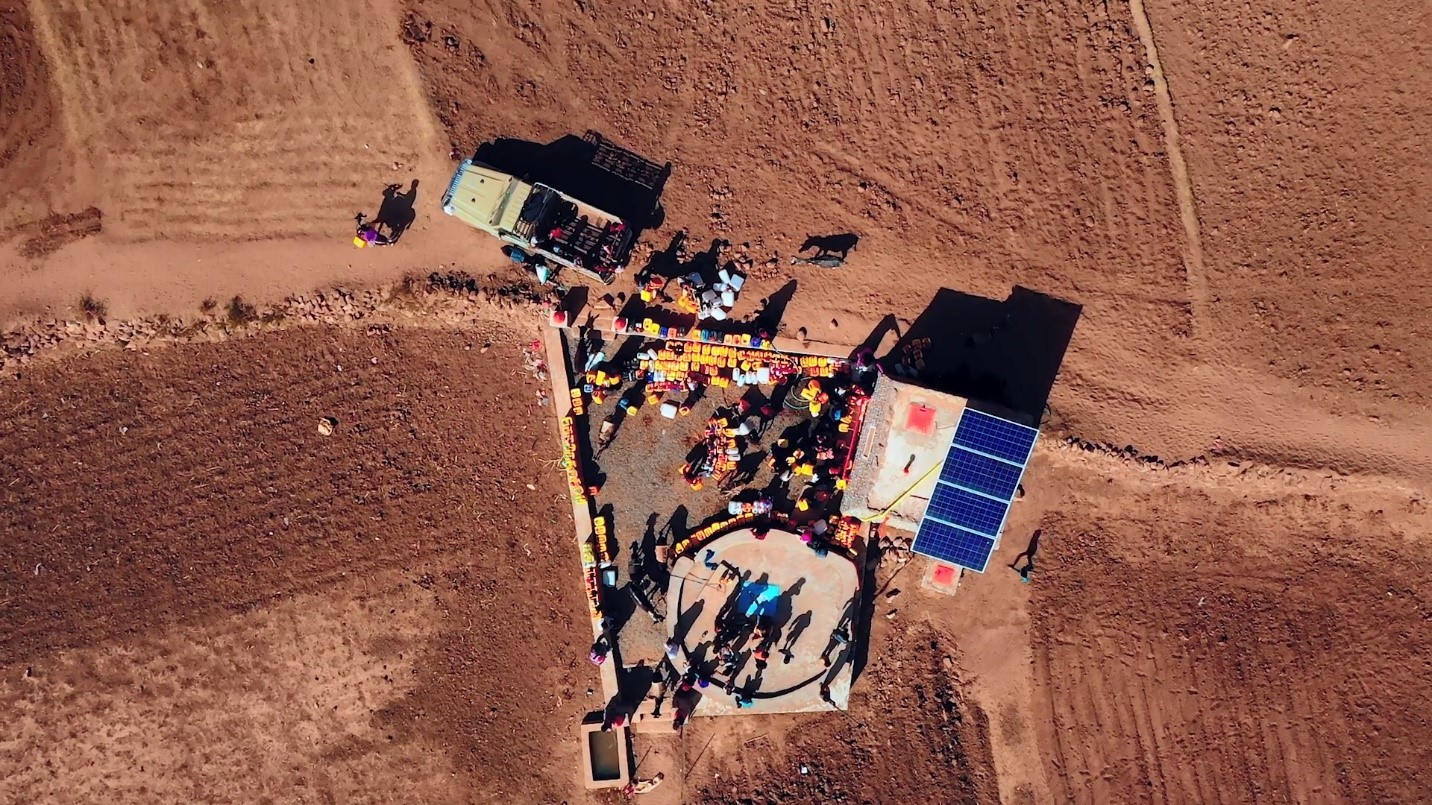 An aerial view of a field with people standing around with trucks