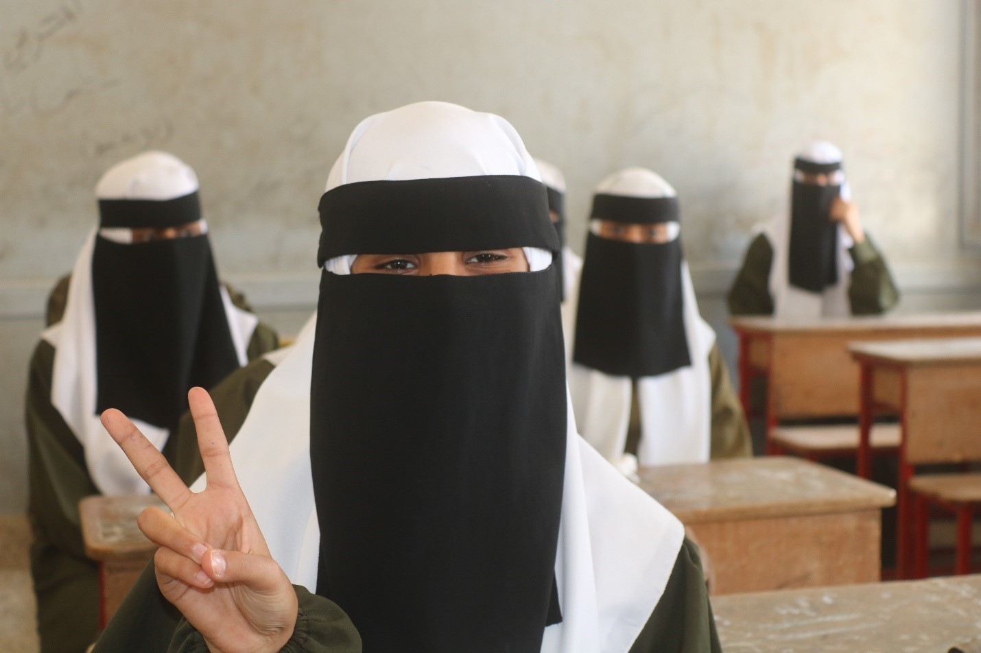 A group of women wearing black and white head coverings