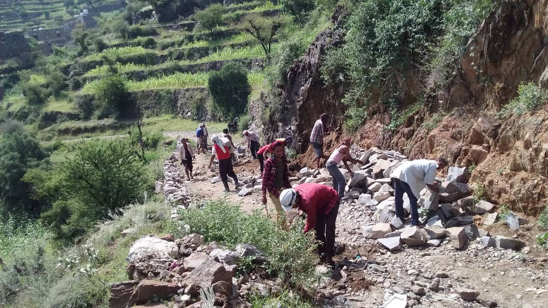 a group of people working on a rocky path