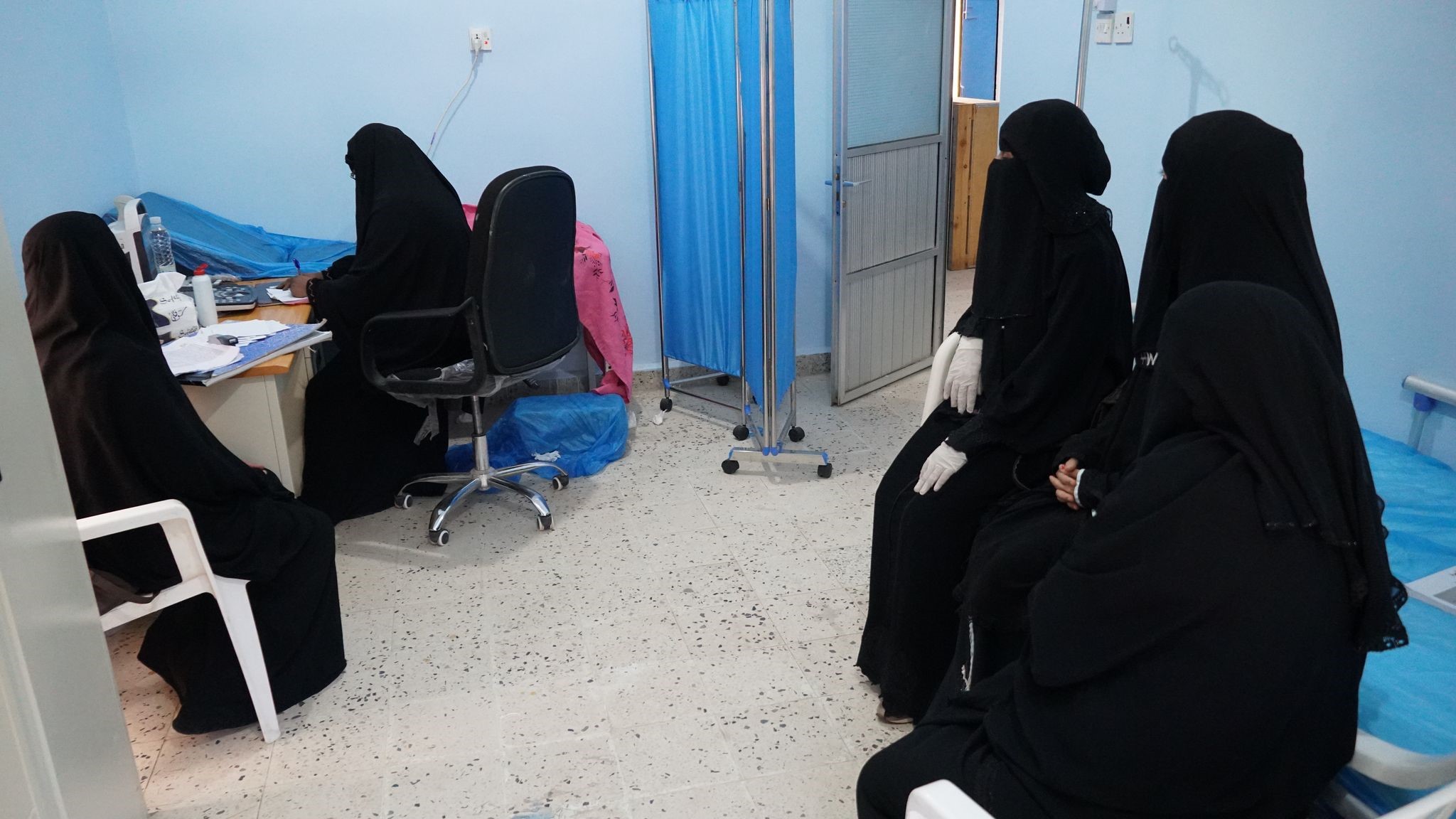 Women wearing black outfits sitting and waiting in a hospital room