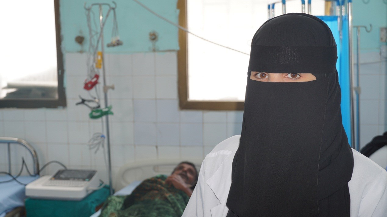 A woman in a hospital wearing a black veil,