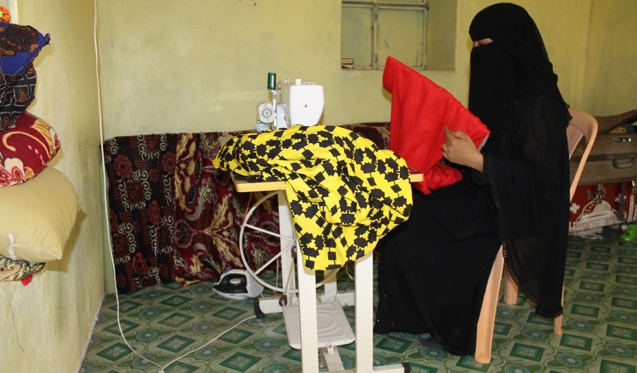 A woman sewing clothes on a sewing machine