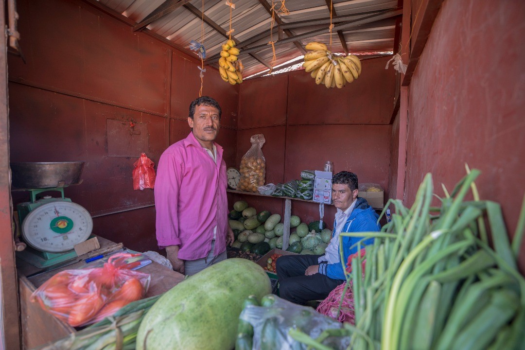 Two men standing in a small market