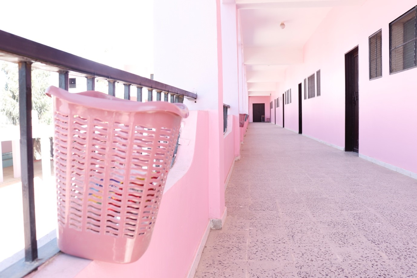 A pink hallway with a basket on the side,