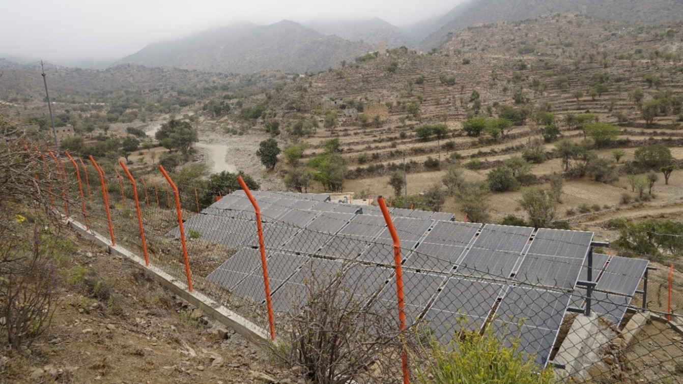 A fence with solar panel in a mountain green landscape