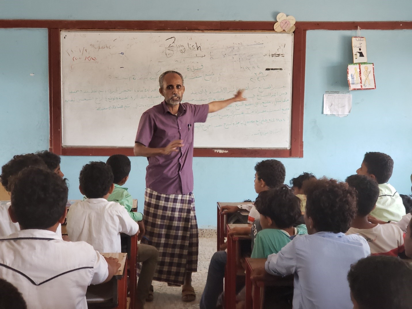 A man standing in front of a class teaching