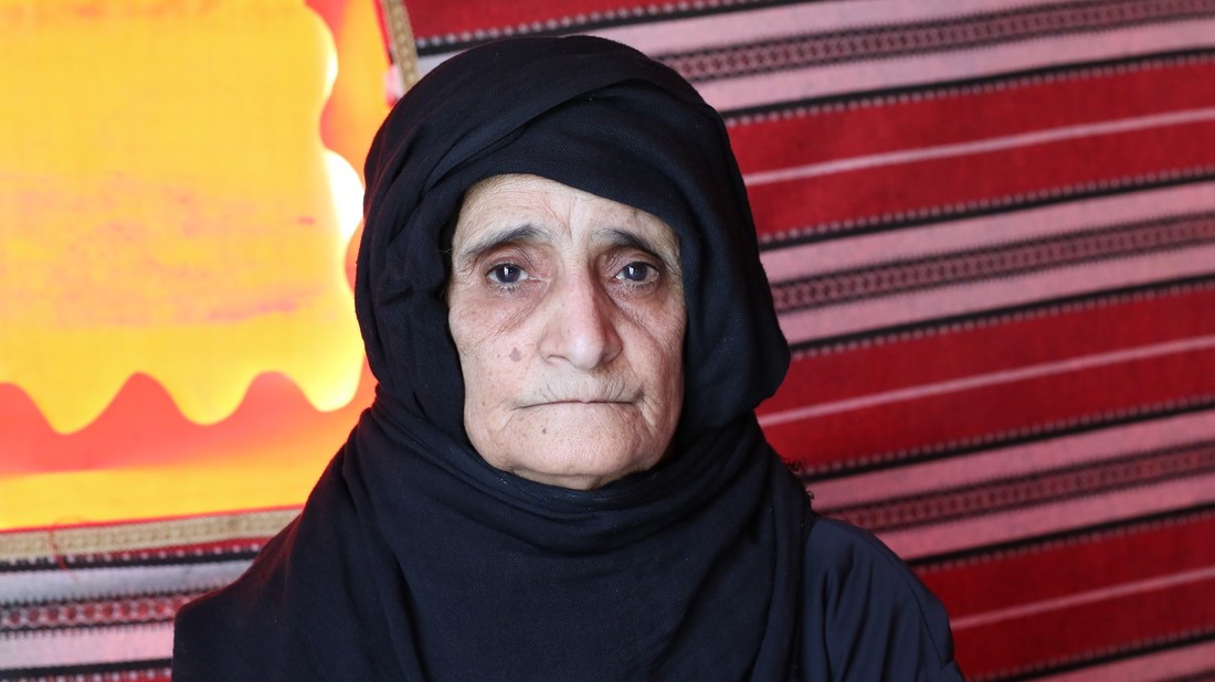 an older woman wearing a black head scarf