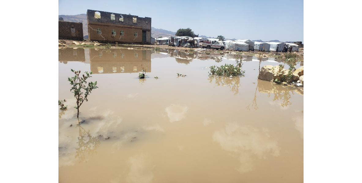a flooded area with buildings and a building in the background