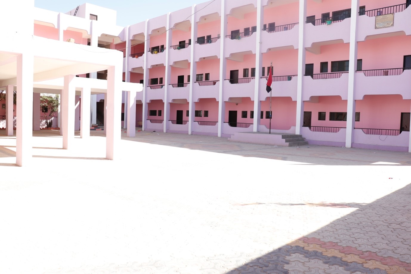 A pink building with a spacious courtyard